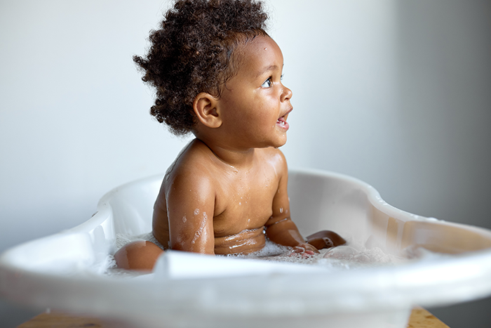 Baby in a bath playing with babies