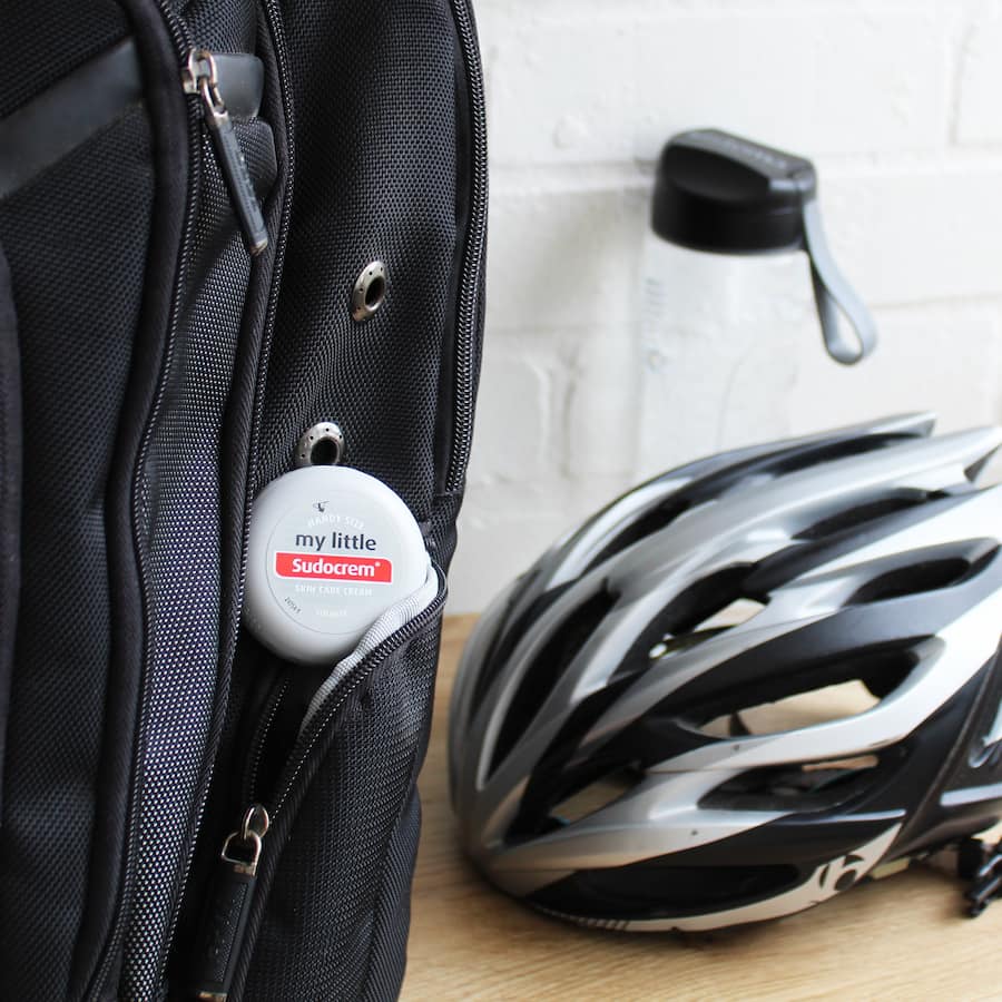 My Little Sudocrem next to a bike helmet in a bag.